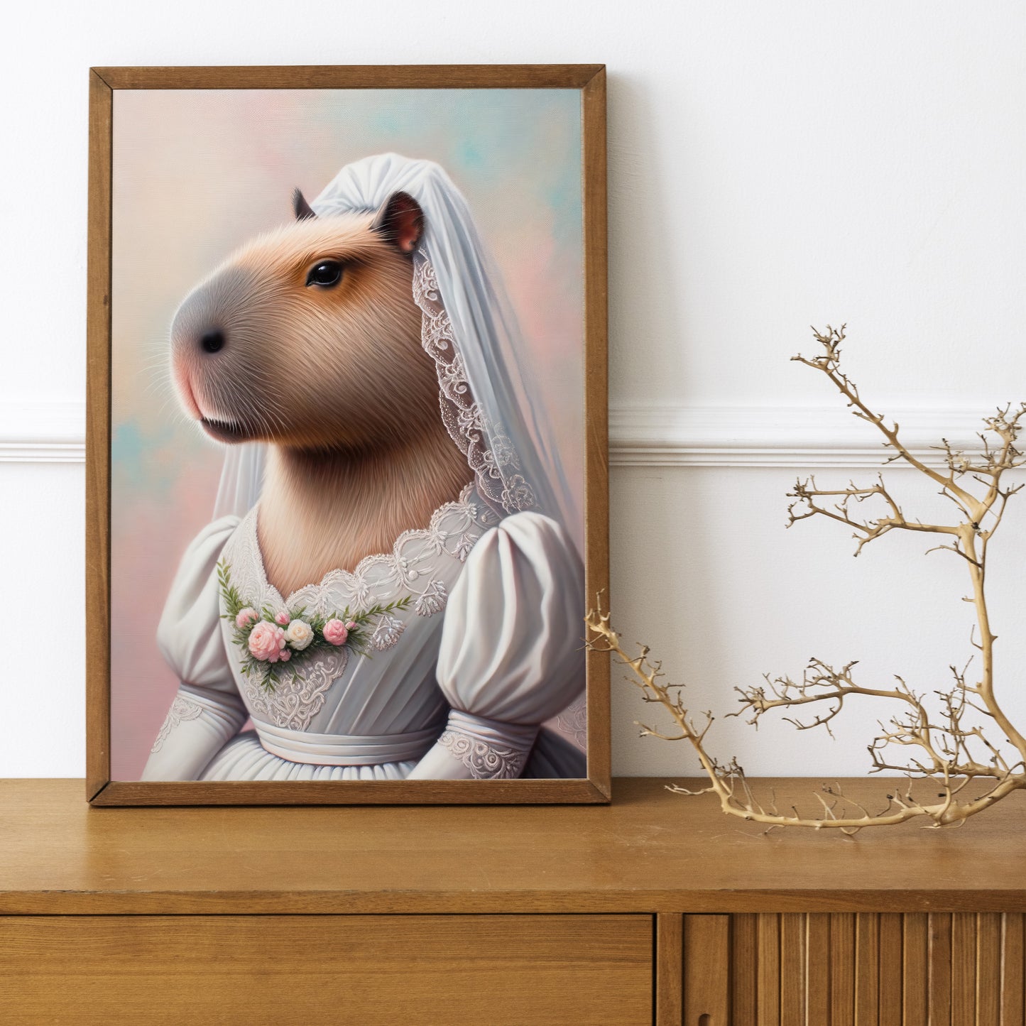 Poster capybara mariée en cadre bois posé sur un buffet en bois, branche sèche décorative