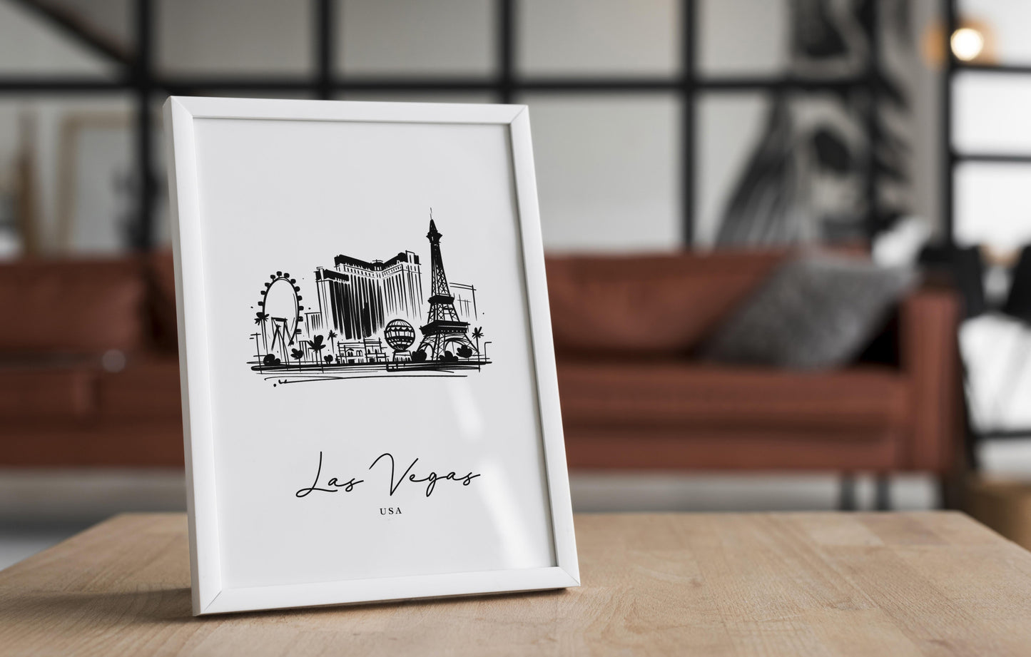 Poster des monuments de Las Vegas dans un cadre blanc posé sur une table en bois, salon avec canapé en cuir