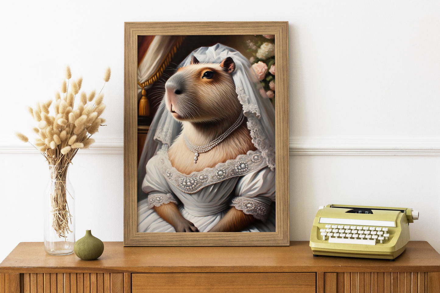 Poster capybara en robe de mariée en cadre bois sur un bureau, machine à écrire et fleurs séchées