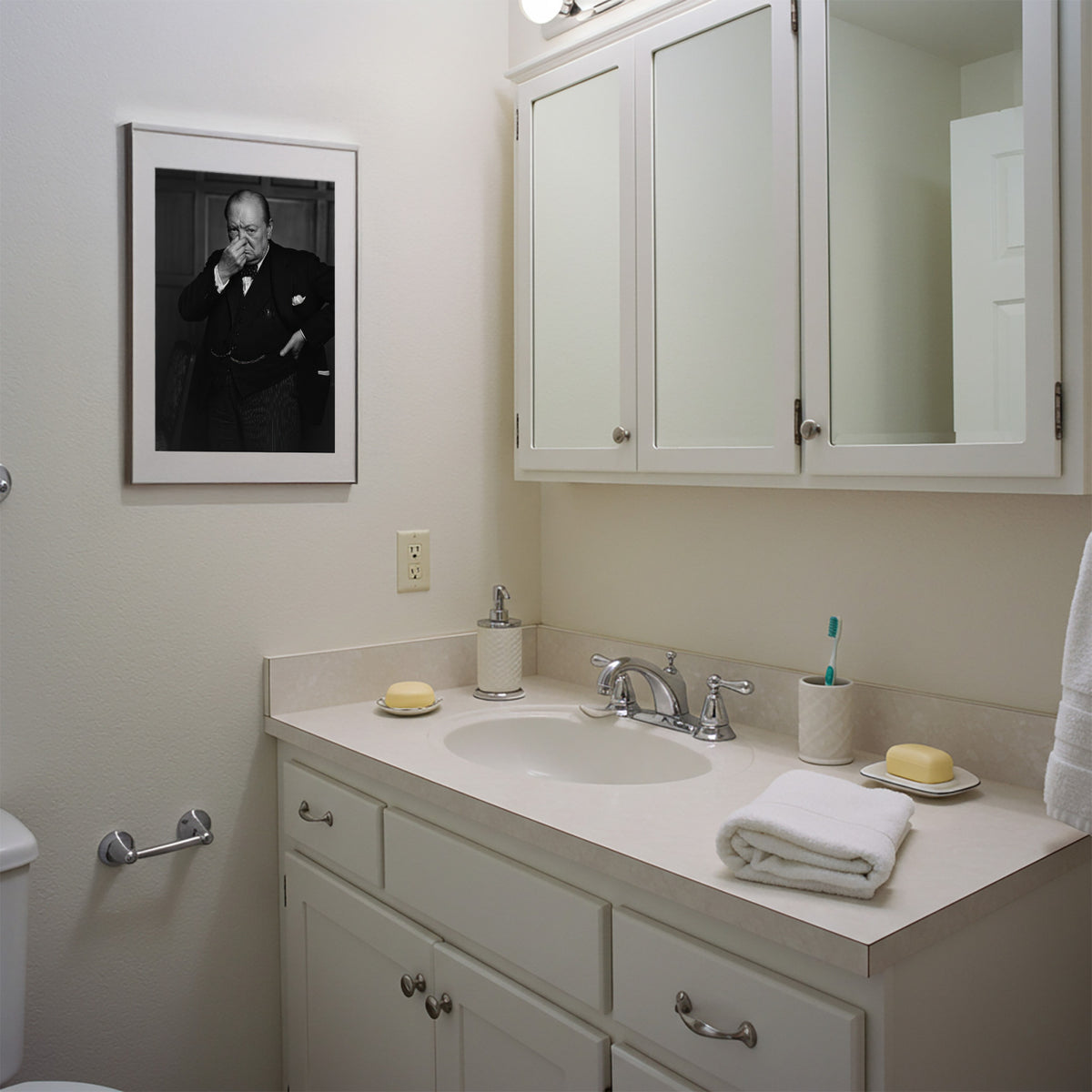 Poster Churchill qui se pince le nez en cadre blanc au-dessus du meuble vasque, salle de bain blanche