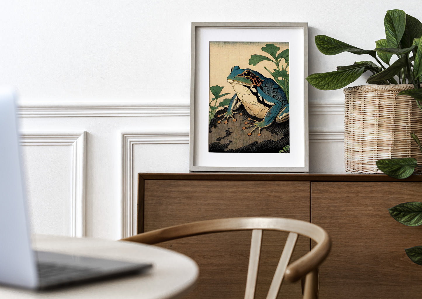 Poster grenouille art japonais, cadre clair et passe-partout sur une commode en bois, plante en panier