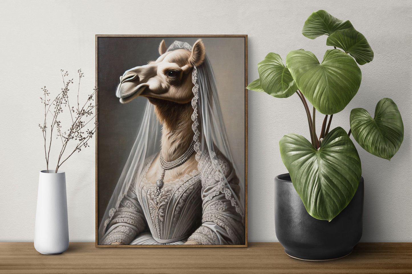 Camel in wedding dress poster in a dark wood frame on a shelf between a white vase and a green plant