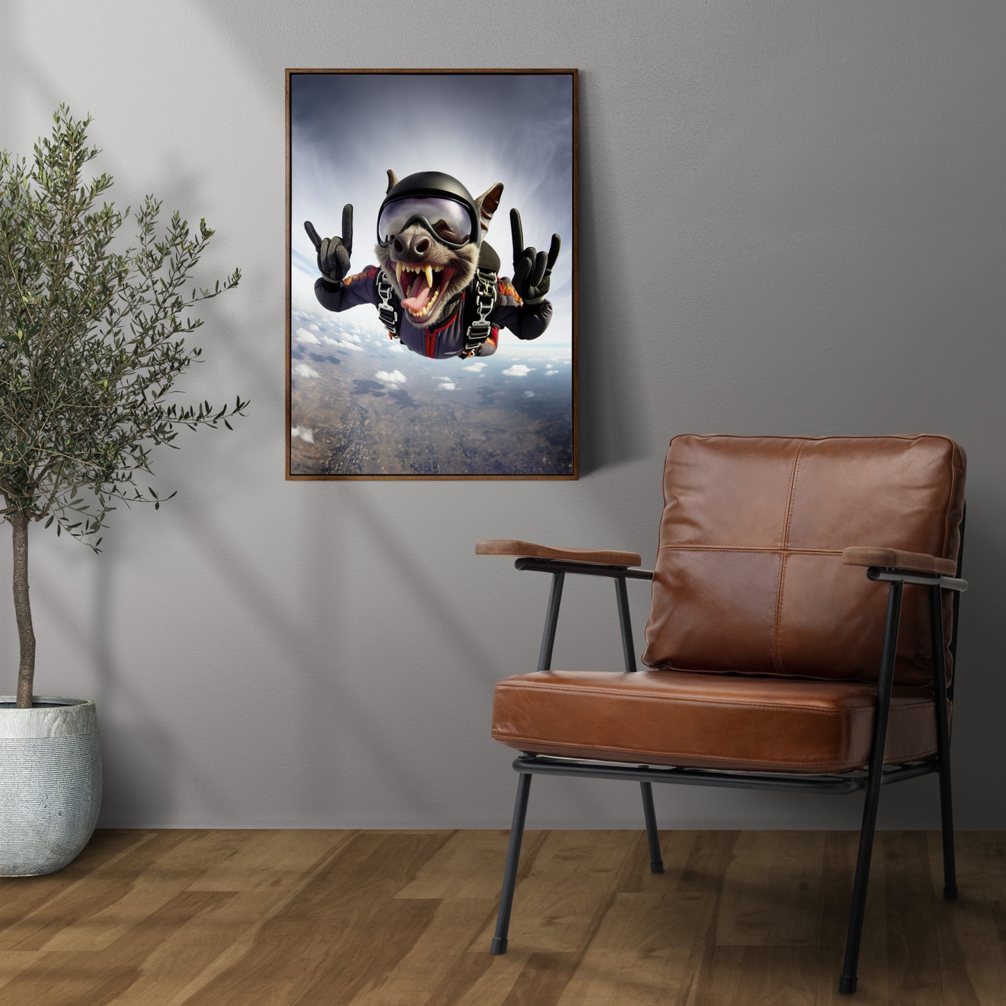 Bat free fall poster in a dark wood frame on a gray wall above a leather armchair and olive tree
