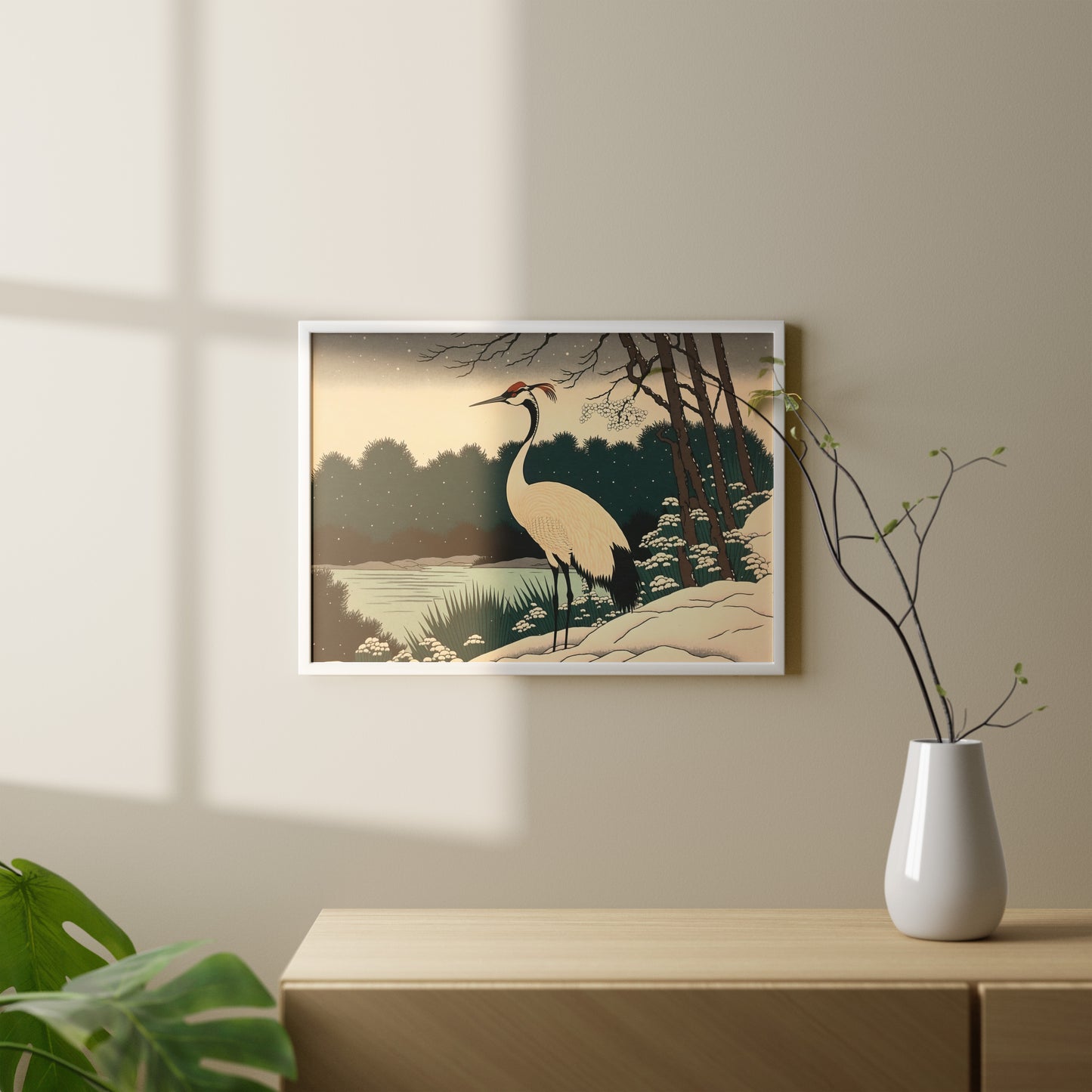 Poster grue du Japon en cadre blanc au-dessus d'une console bois clair, vase et branches