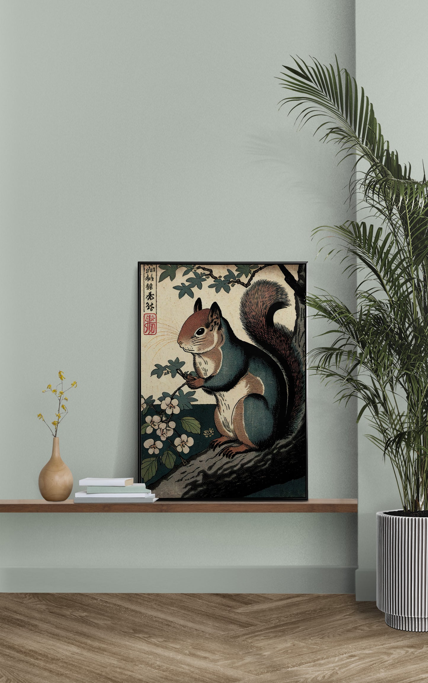 Poster écureuil art japonais posé sur une étagère murale, mur vert sauge et palmier en pot