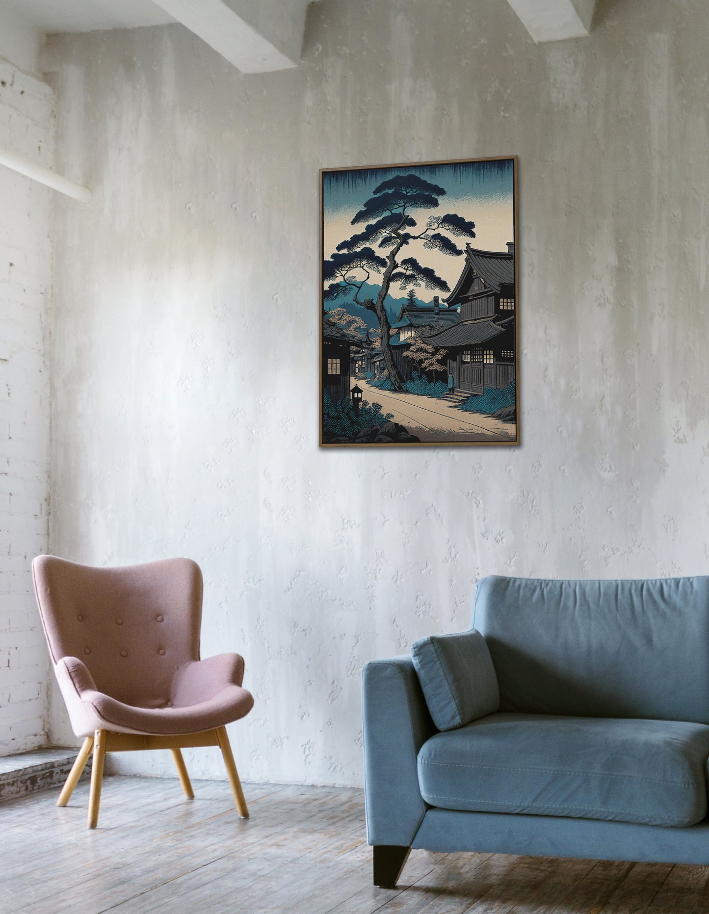 Affiche village japonais bleu accrochée sur un mur en béton, fauteuil rose et canapé bleu