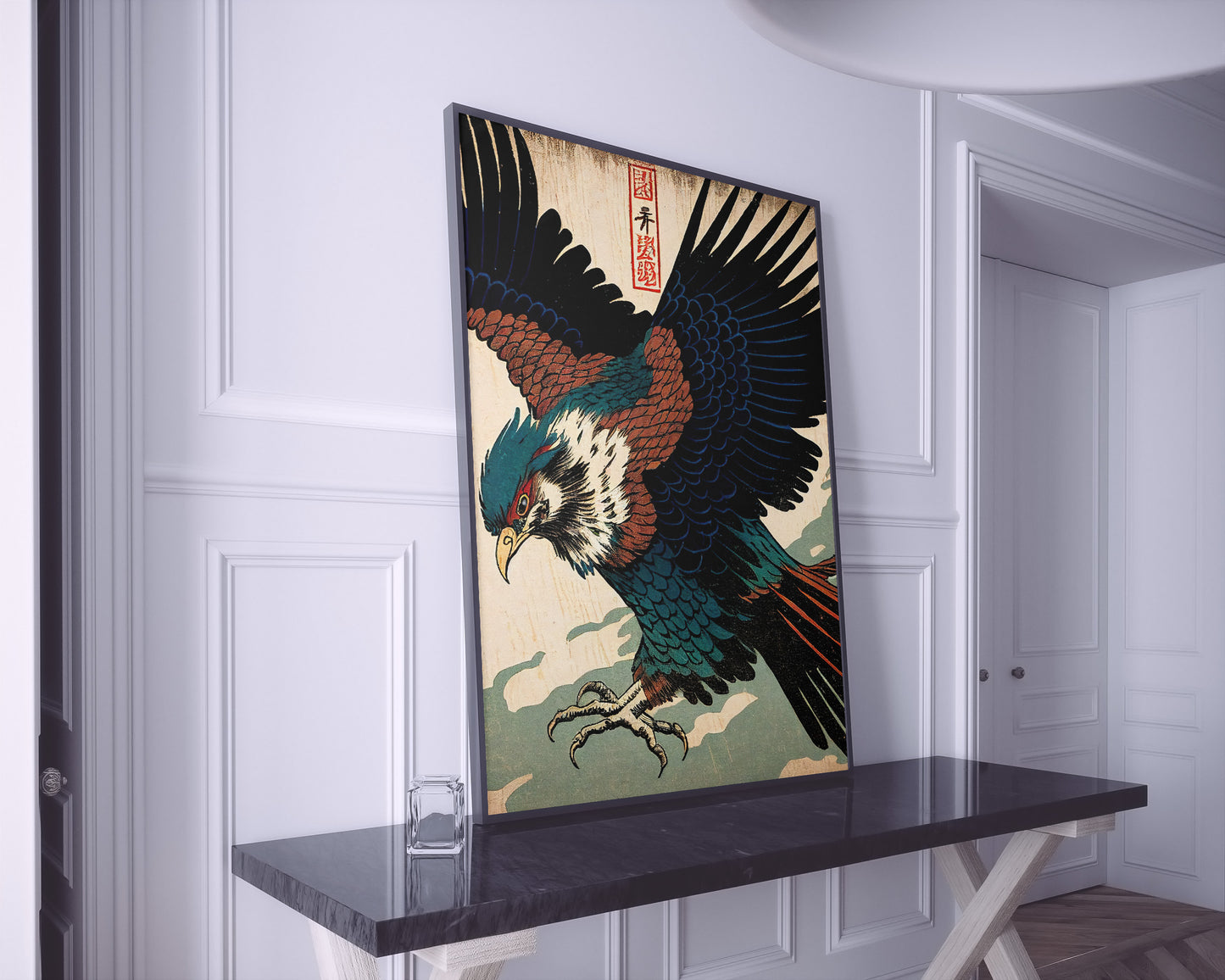 Grand poster aigle japonais posé sur une console en marbre noir, pièce blanche à moulures
