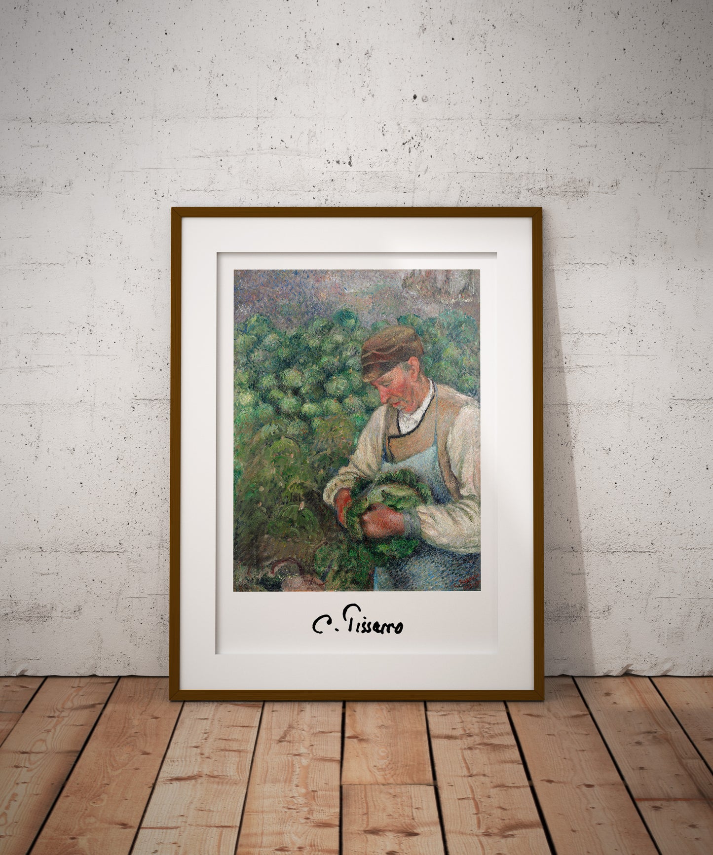 Affiche Pissarro paysan, cadre bois foncé et passe-partout, posée au sol contre un mur blanc