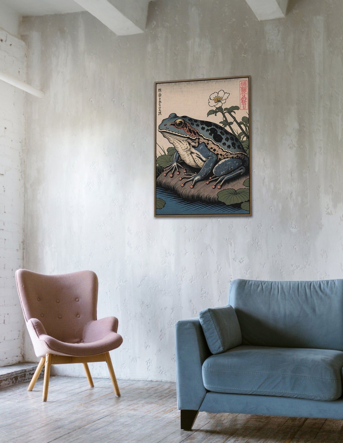 Poster grenouille japonaise accroché sur un mur en béton, fauteuil rose et canapé bleu
