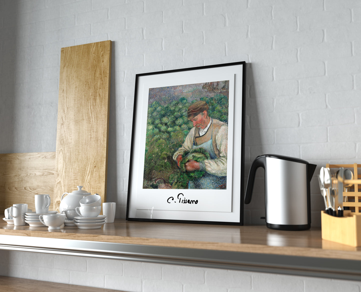 Affiche Pissarro vieux paysan, cadre noir et passe-partout, posée sur un plan de travail de cuisine