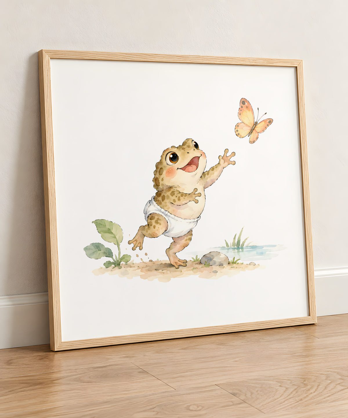 Bébé crapaud en couche essaie d’attraper un papillon dans les herbes : cadre bois clair, 50 × 50 cm, en situation