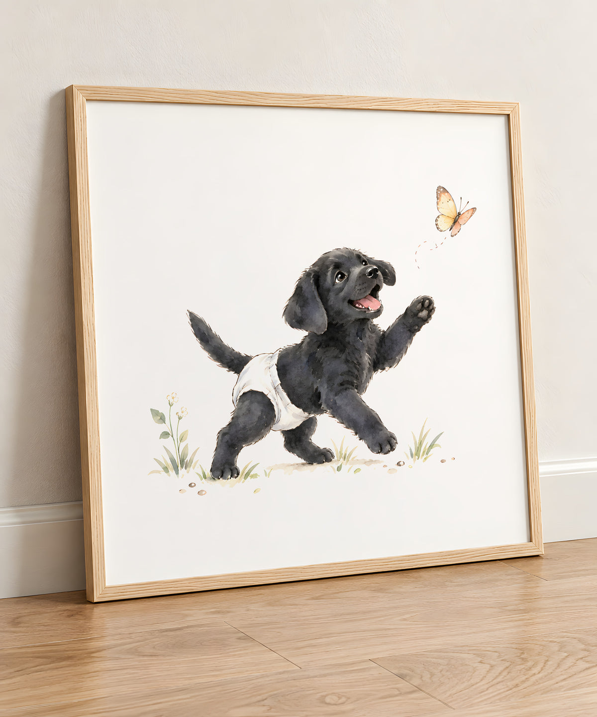 Chiot labrador noir en couche blanche court après un papillon : cadre bois clair, 50 × 50 cm, en situation