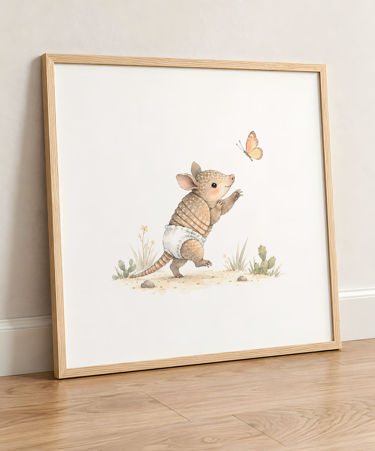 Petit tatou en couche blanche qui tente d’attraper un papillon : cadre bois clair, 50 × 50 cm, en situation