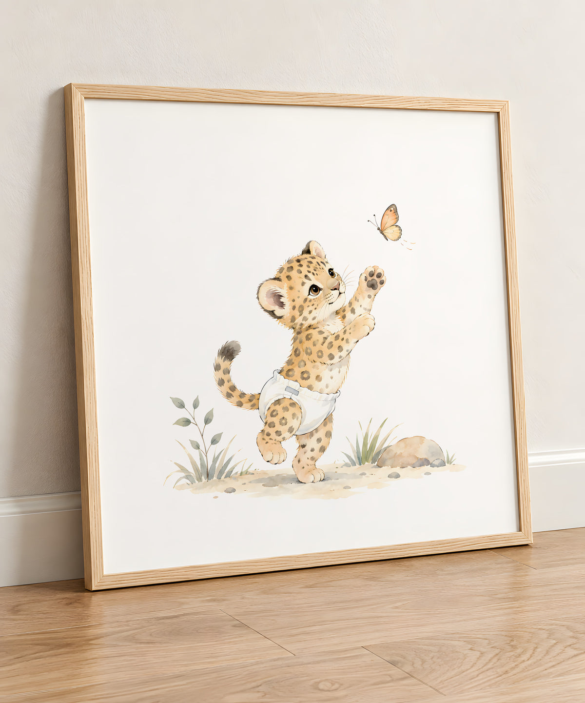 Bébé léopard en couche blanche poursuit un papillon : cadre bois clair, 50 × 50 cm, en situation