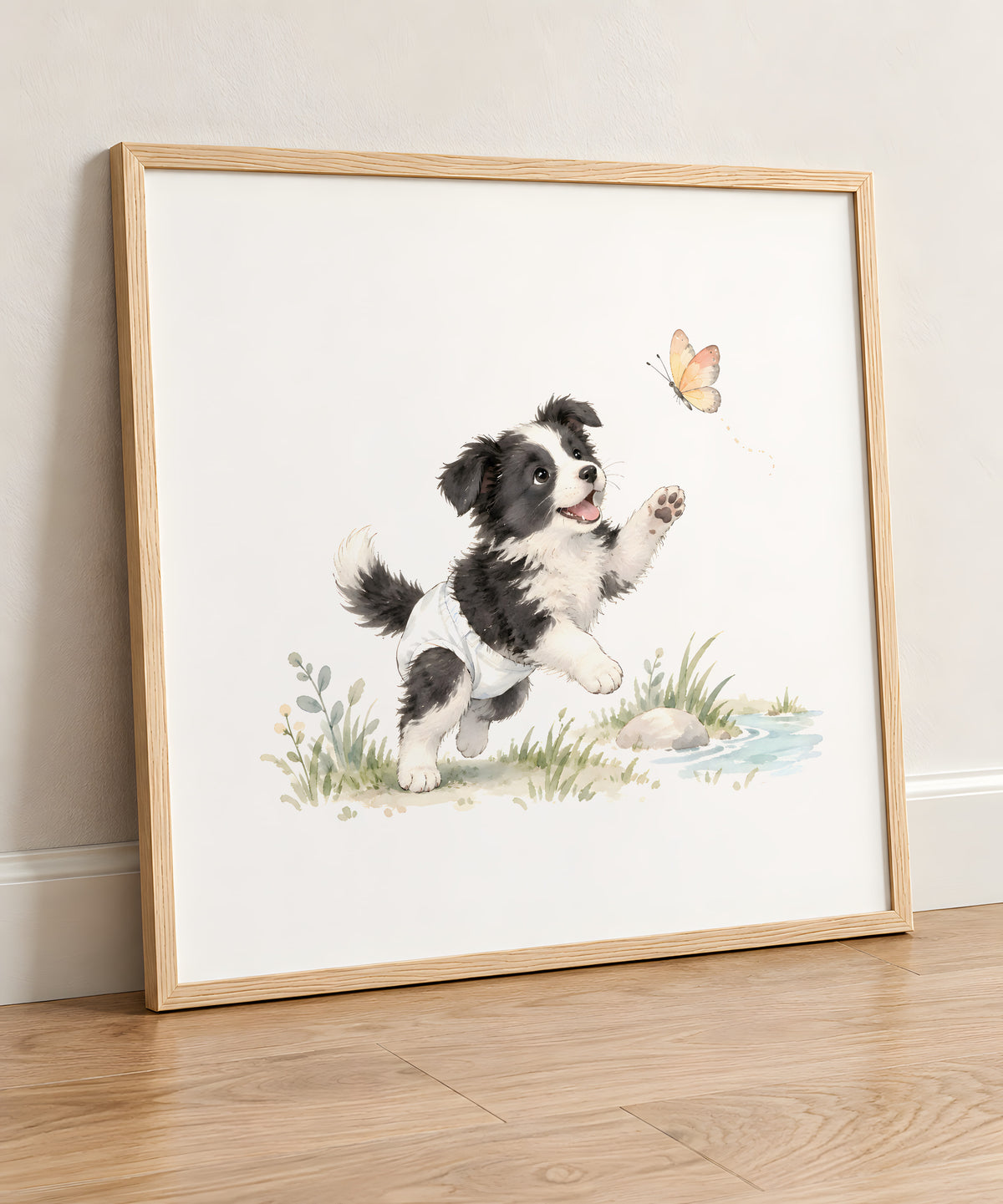 Bébé border collie en couche blanche essaie de rejoindre un papillon : cadre bois clair, 50 × 50 cm, en situation