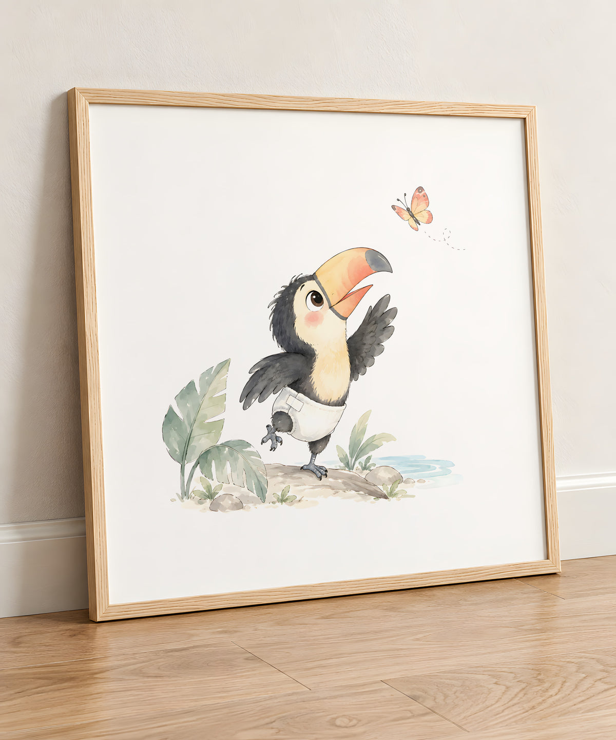 Bébé toucan en couche blanche tente d’attraper un papillon : cadre bois clair, 50 × 50 cm, en situation