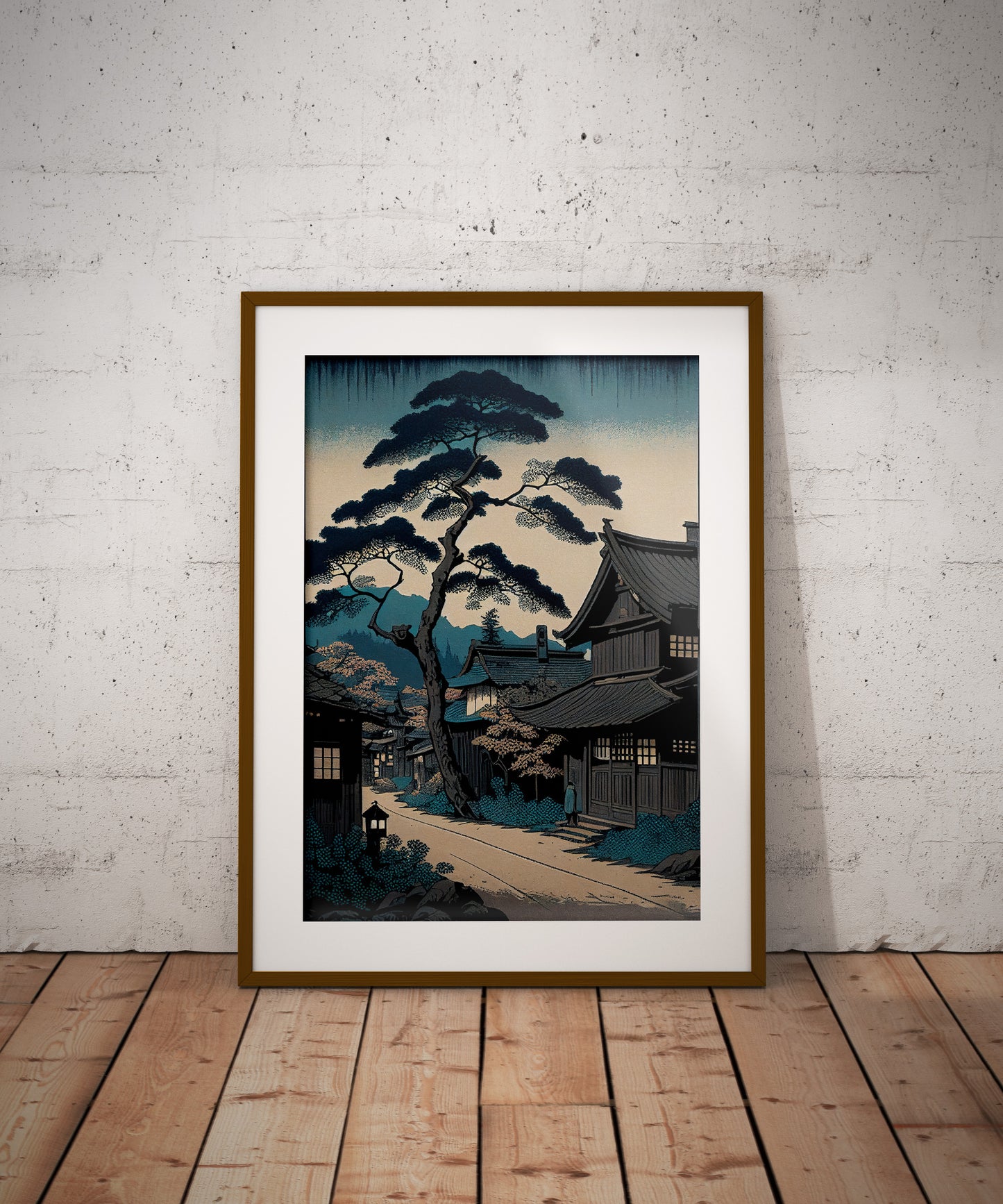Affiche village japonais, cadre bois foncé et passe-partout, posée au sol contre un mur de briques