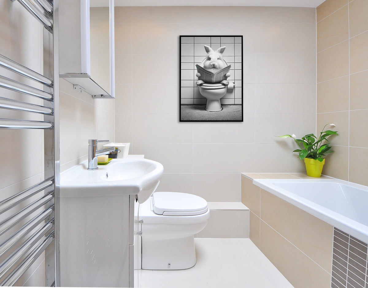 Poster lapin lisant le journal aux toilettes en cadre noir dans une salle de bain claire avec baignoire