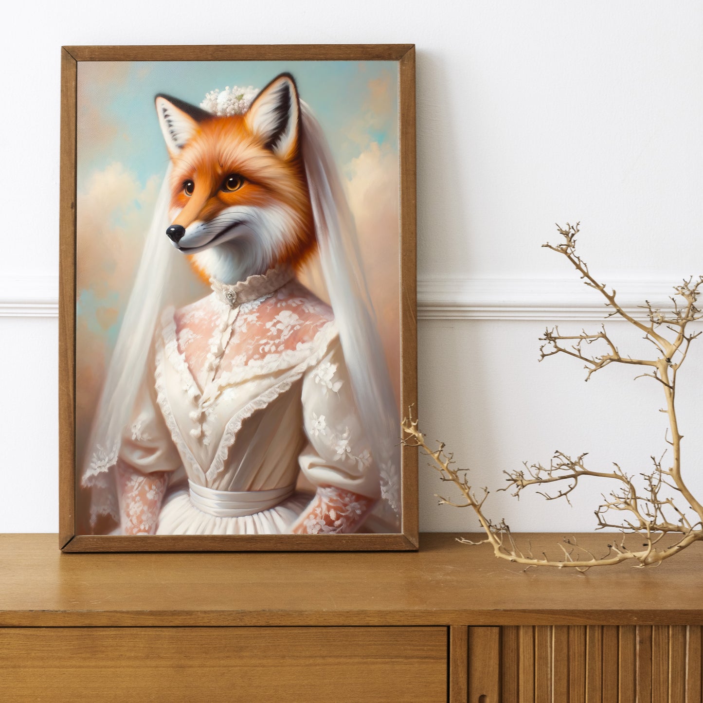 Fox in wedding dress poster in a dark wood frame on a wooden sideboard with a decorative branch