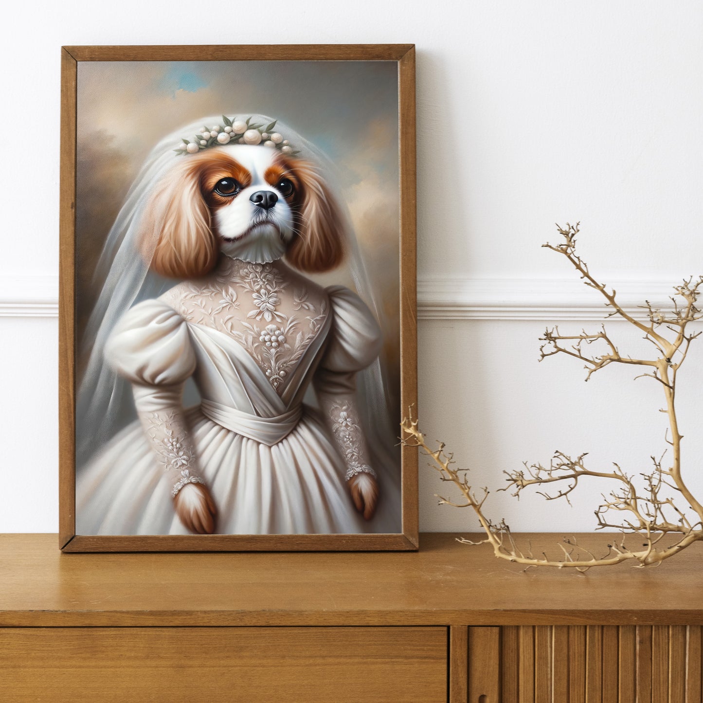 Poster Cavalier King Charles en robe de mariée, cadre bois foncé sur un buffet en bois avec une branche décorative