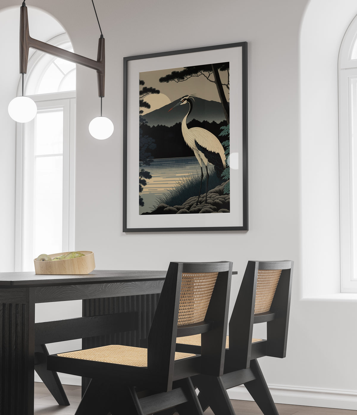 Poster grue du Japon, cadre noir et passe-partout, au-dessus d'une table noire et de chaises cannées