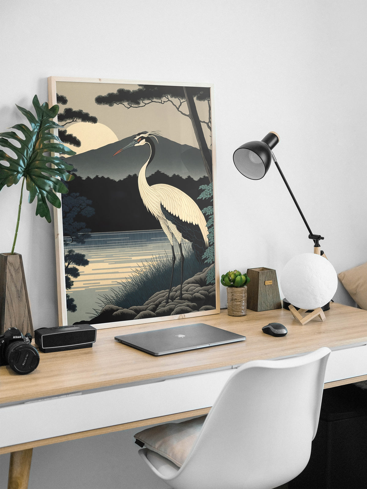 Poster grue du Japon en cadre bois clair posé sur un bureau, ordinateur et lampe noire