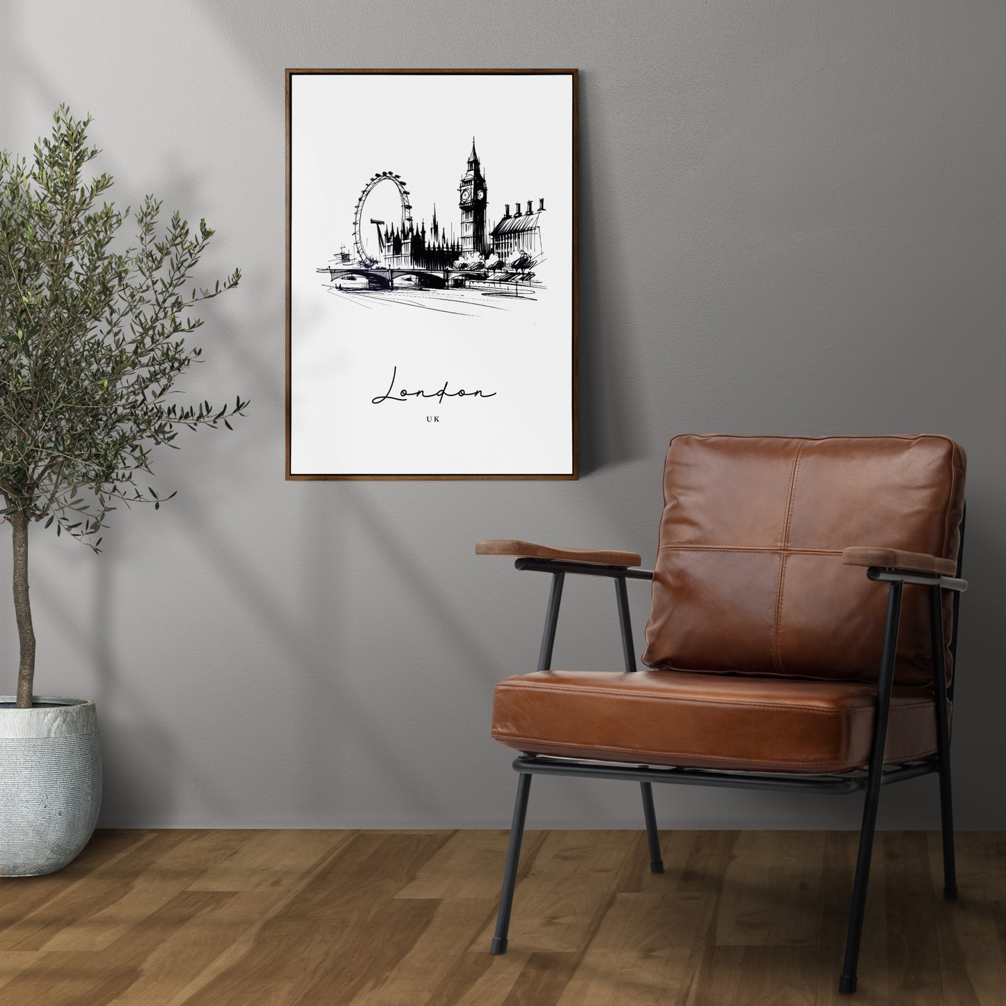 Poster Londres noir et blanc en cadre bois foncé sur un mur gris, à côté d'un fauteuil en cuir et d'un olivier