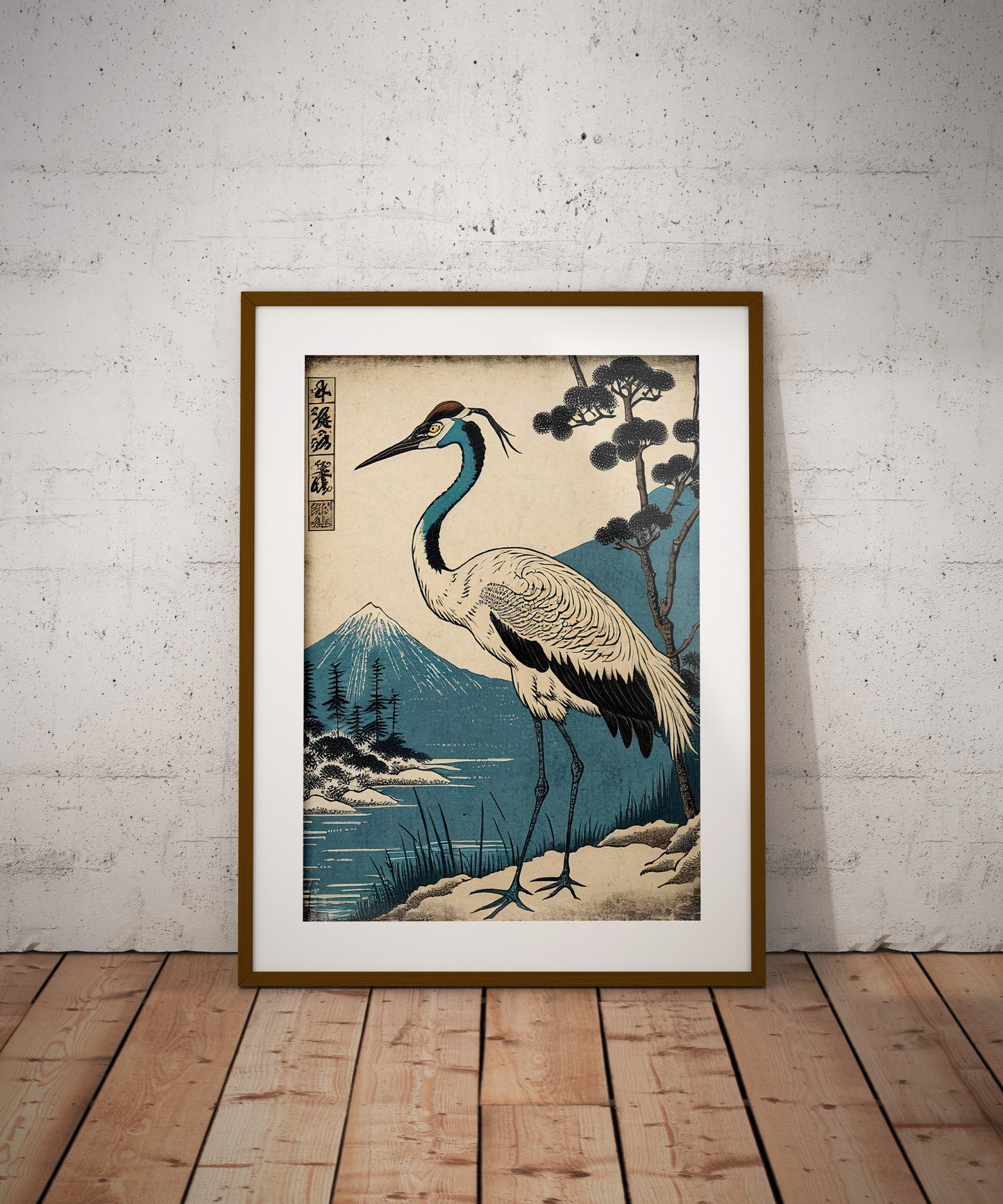 Poster grue du Japon, cadre bois foncé et passe-partout, posé au sol contre un mur de briques