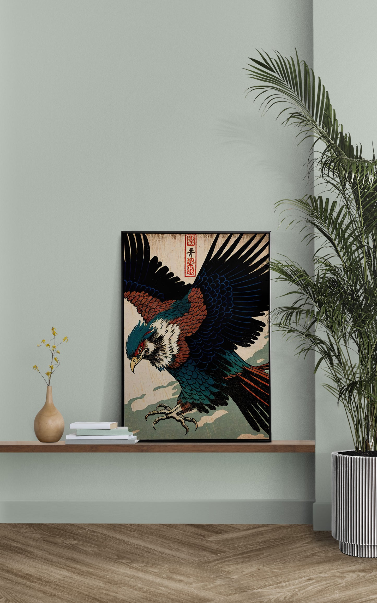 Poster aigle japonais posé sur une étagère murale, mur vert sauge et palmier en pot