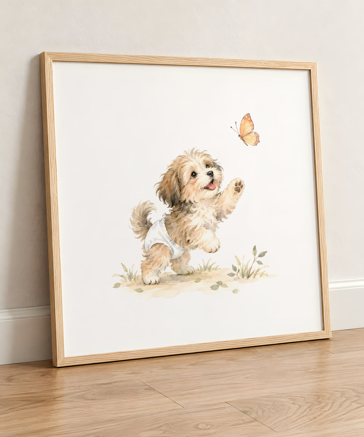 Bébé bichon havanais en couche blanche tend les pattes vers un papillon : cadre bois clair, 50 × 50 cm, en situation