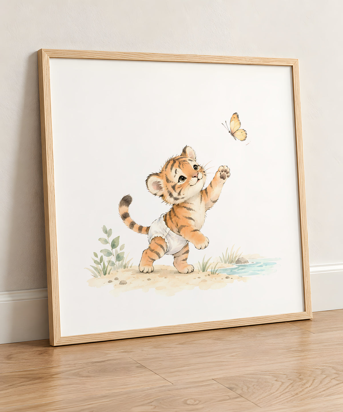 Bébé tigre en couche blanche à la poursuite d’un papillon : cadre bois clair, 50 × 50 cm, en situation