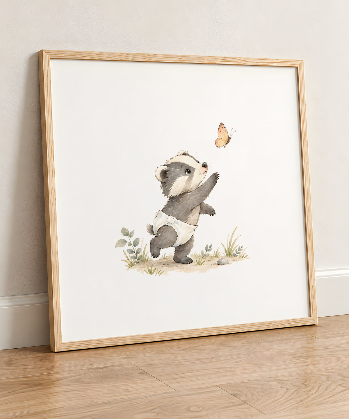 Un bébé blaireau essaie d’attraper un papillon : cadre bois clair, 50 × 50 cm, en situation