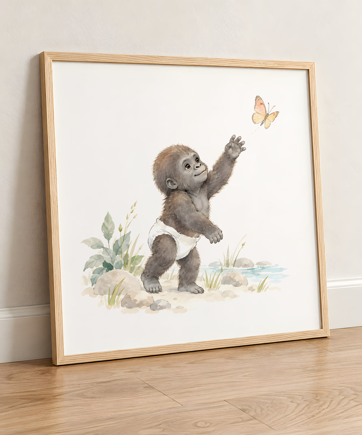 Bébé gorille en couche blanche essaie d’attraper un papillon : cadre bois clair, 50 × 50 cm, en situation