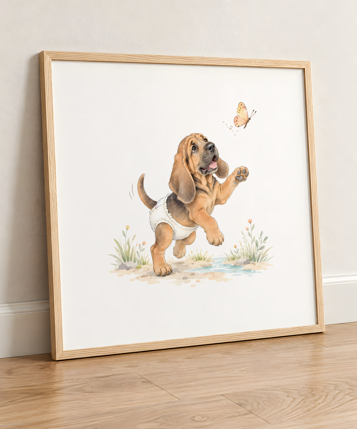 Chiot saint-hubert aux longues oreilles essaie d’attraper un papillon : cadre bois clair, 50 × 50 cm, en situation