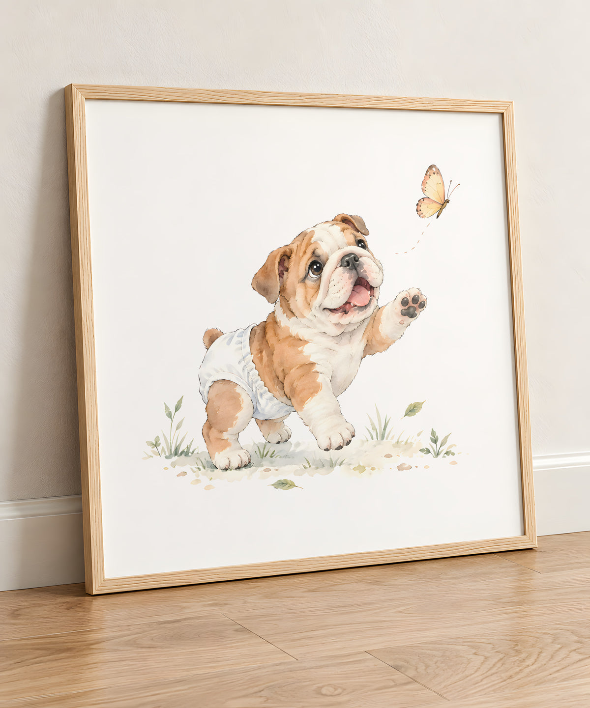 Bébé bouledogue anglais en couche blanche tente de saisir un papillon : cadre bois clair, 50 × 50 cm, en situation