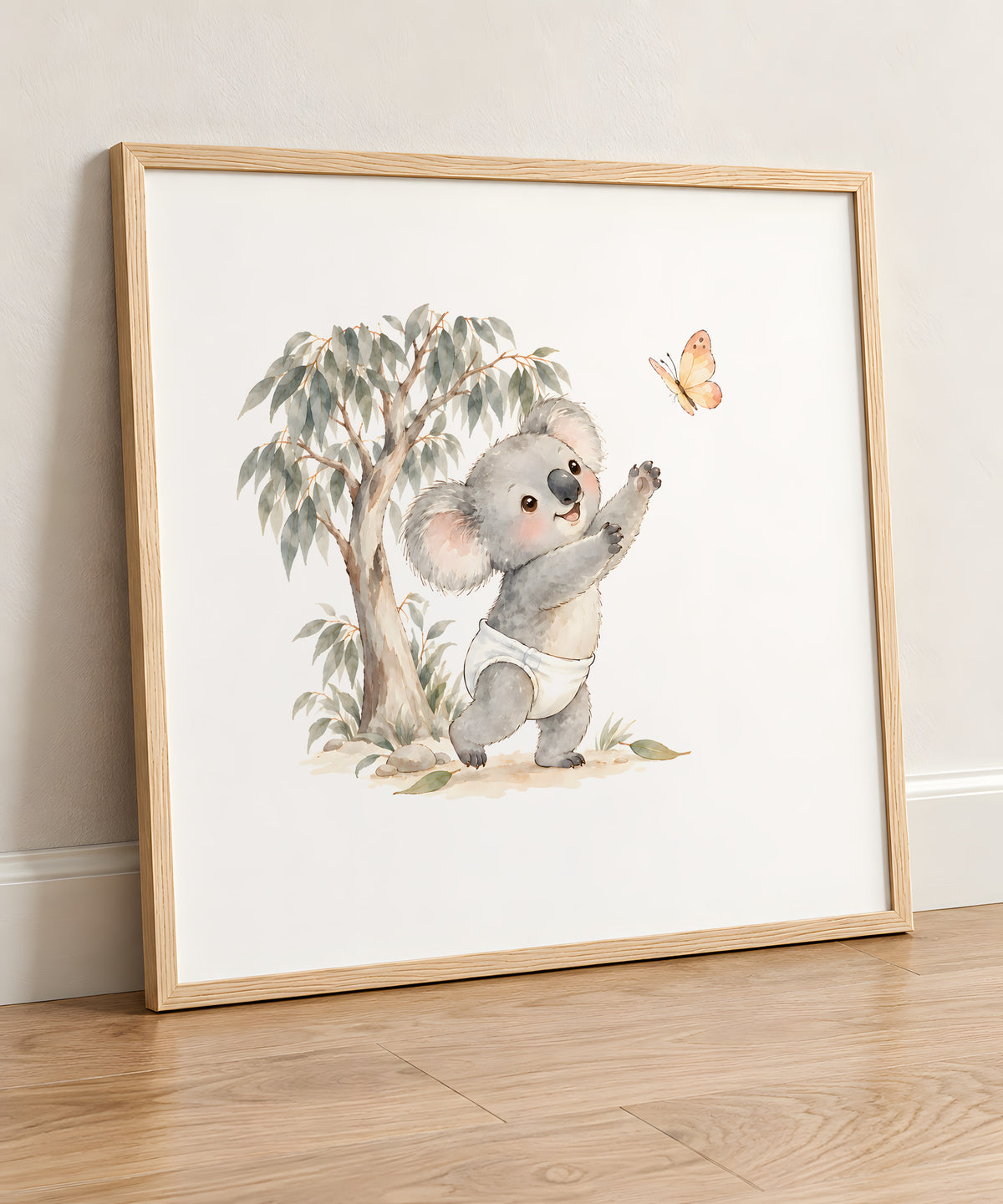 Bébé koala poursuit un papillon près des eucalyptus : cadre bois clair, 50 × 50 cm, en situation