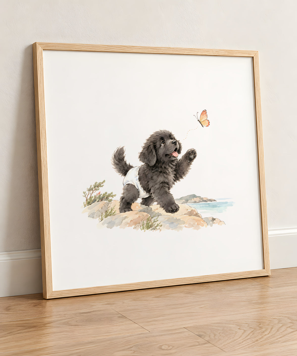 Bébé terre-neuve en couche blanche suit un papillon sur le rivage : cadre bois clair, 50 × 50 cm, en situation