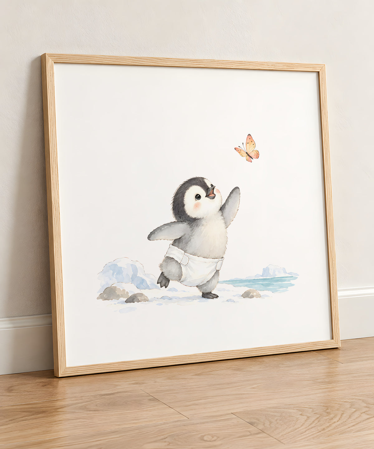 Bébé manchot en couche blanche cherche à attraper un papillon : cadre bois clair, 50 × 50 cm, en situation