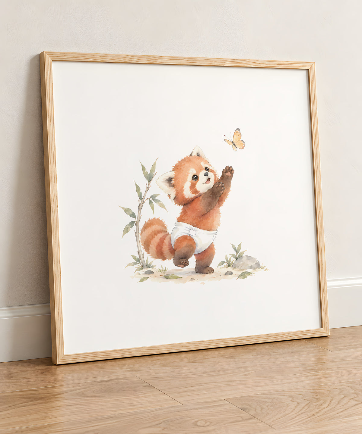 Bébé panda roux en couche blanche à la poursuite d’un papillon : cadre bois clair, 50 × 50 cm, en situation
