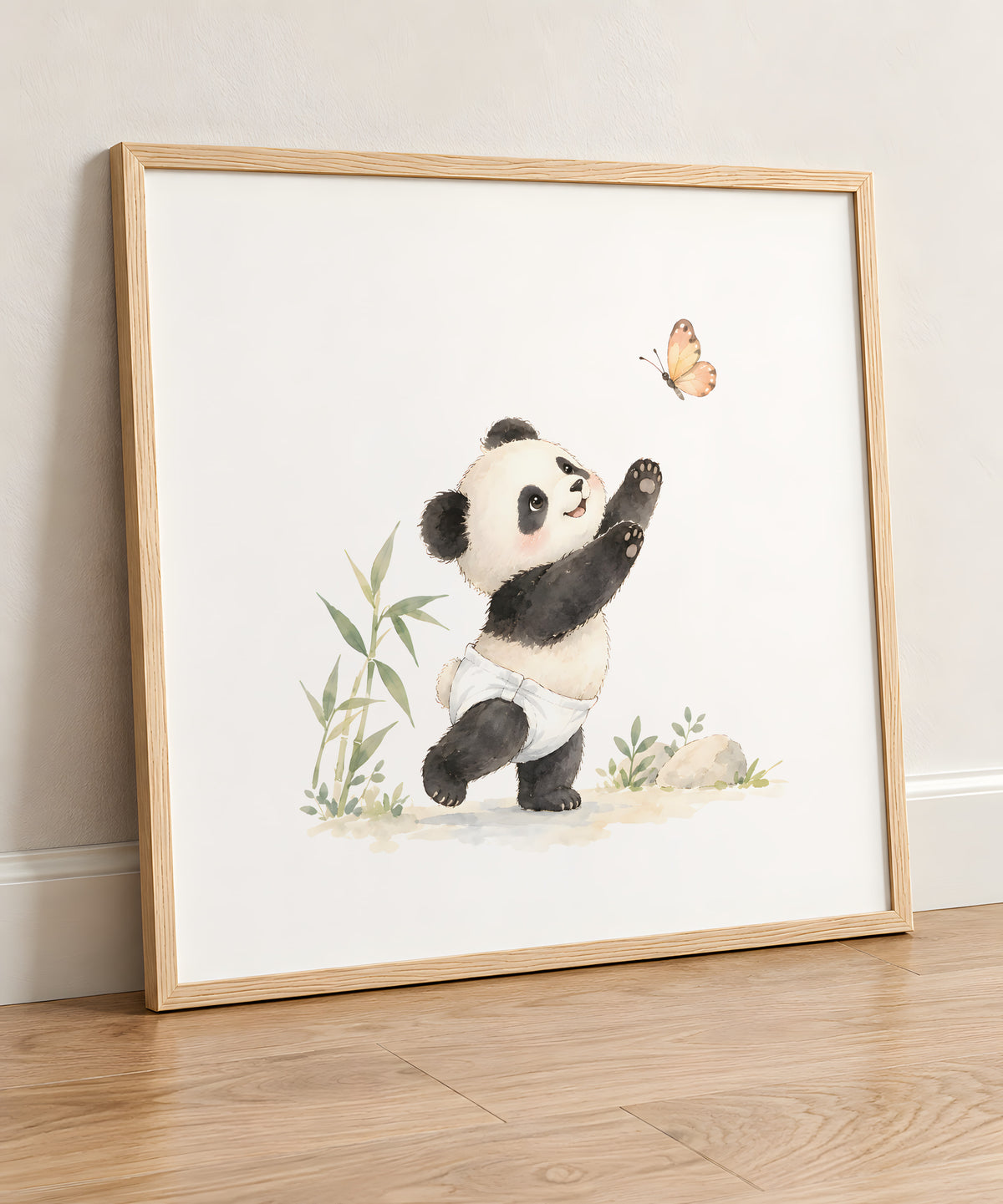 Bébé panda en couche blanche essaie d’attraper un papillon : cadre bois clair, 50 × 50 cm, en situation