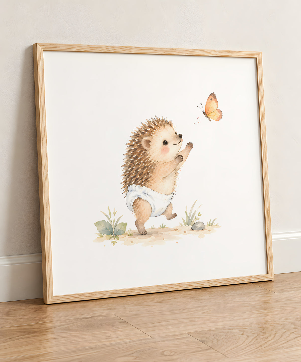 Petit hérisson en couche blanche essaie de saisir un papillon : cadre bois clair, 50 × 50 cm, en situation