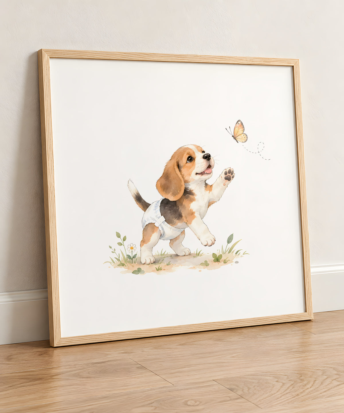 Bébé beagle en couche blanche tend les pattes vers un papillon : cadre bois clair, 50 × 50 cm, en situation