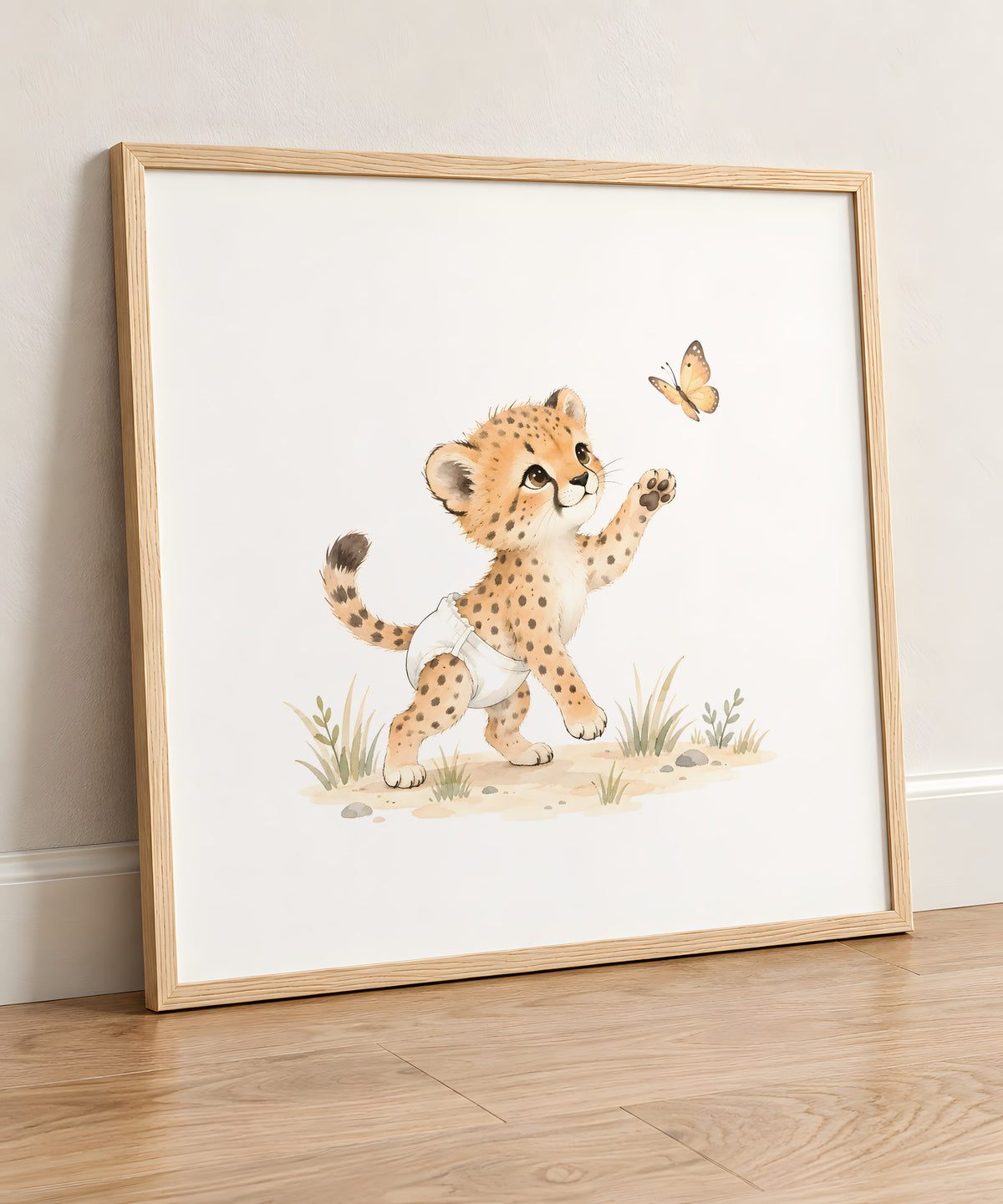 Bébé guépard en couche blanche essaie de saisir un papillon : cadre bois clair, 50 × 50 cm, en situation