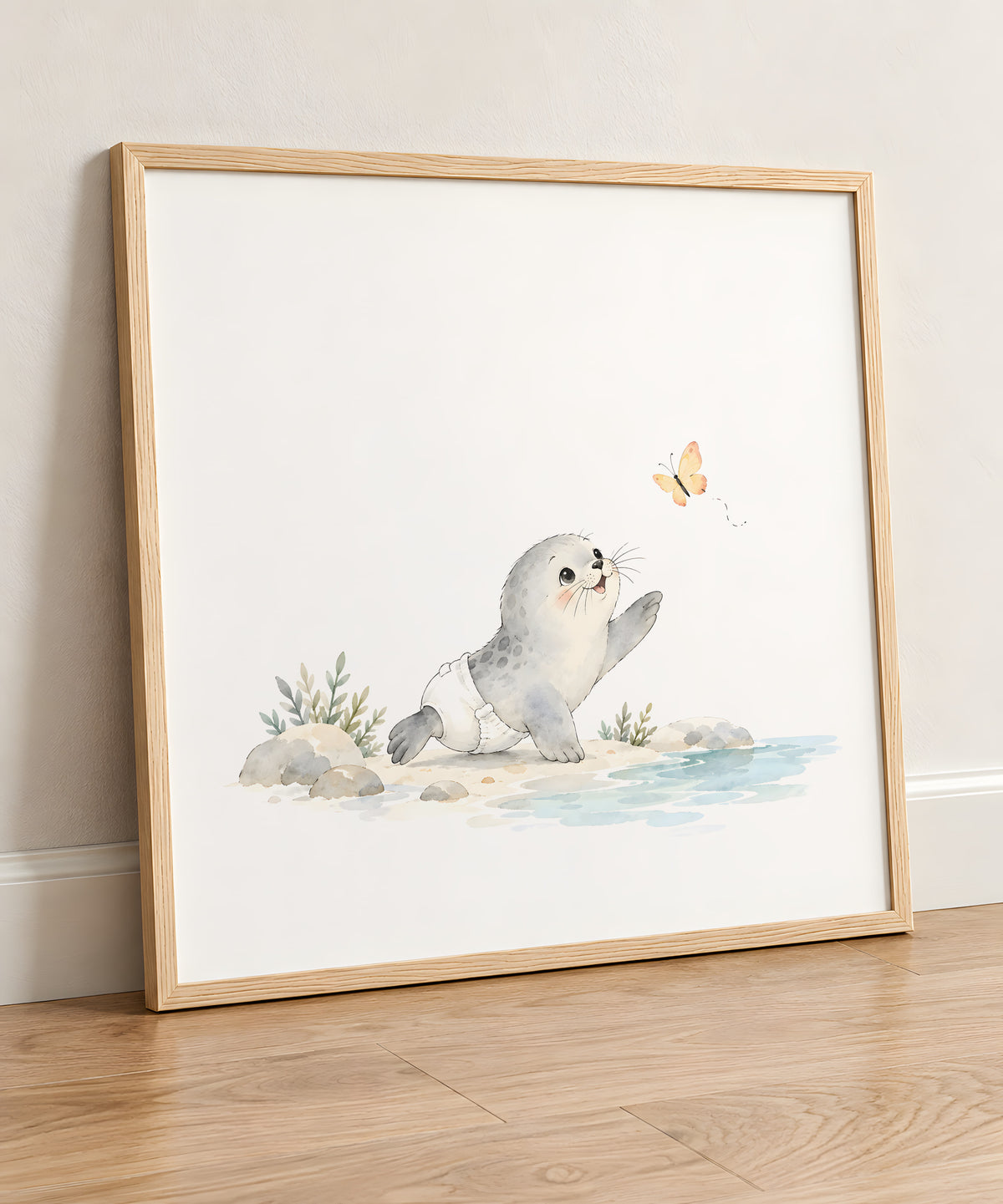 Bébé phoque en couche blanche essaie d’attraper un papillon : cadre bois clair, 50 × 50 cm, en situation